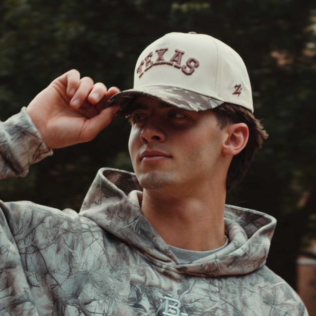 Texas camo hat lifestyle photo, cream cap with tan Texas embroidery styled for everyday wear