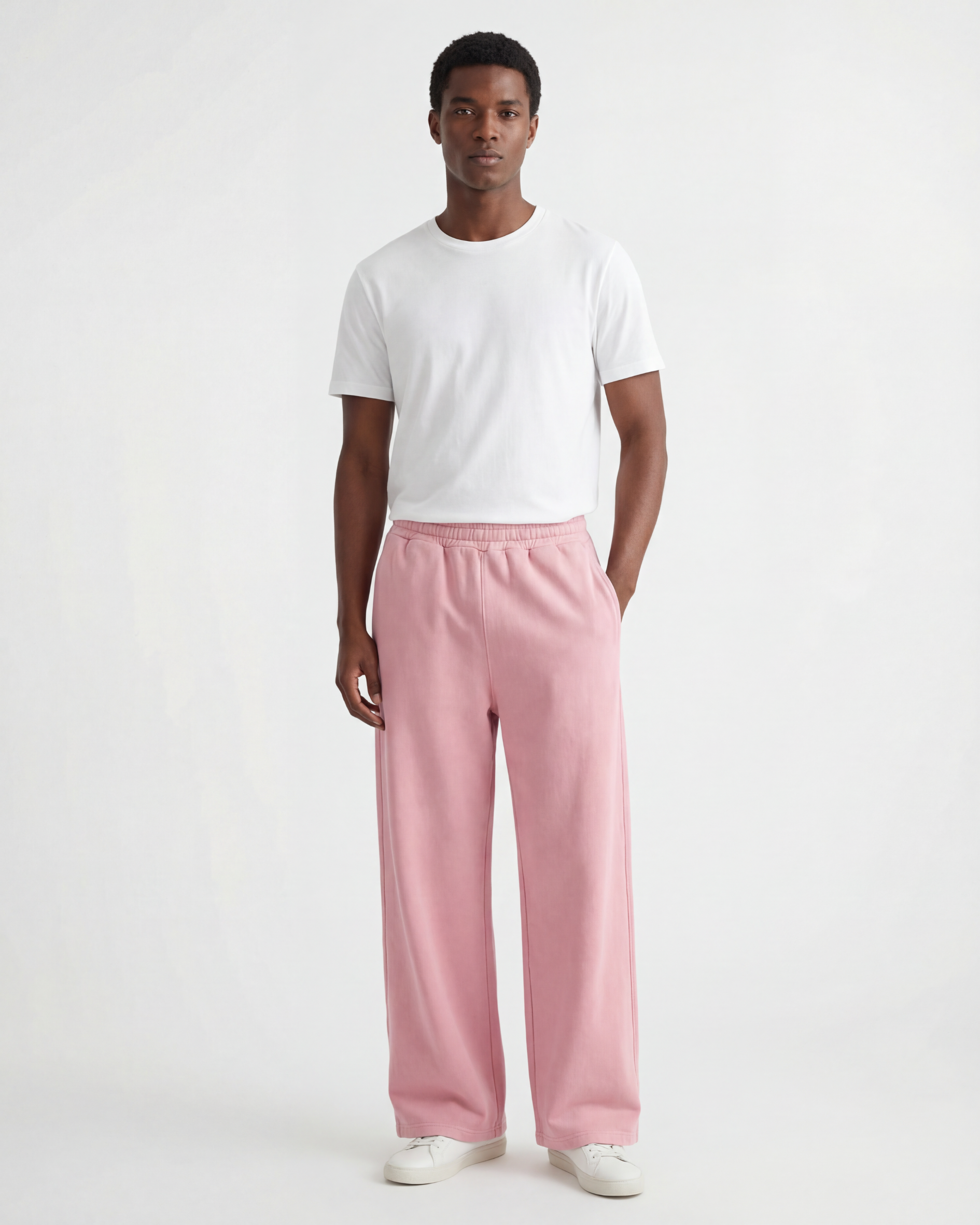 Black Model in a white background wearing pink wide-leg acid wash pants and a white t-shirt