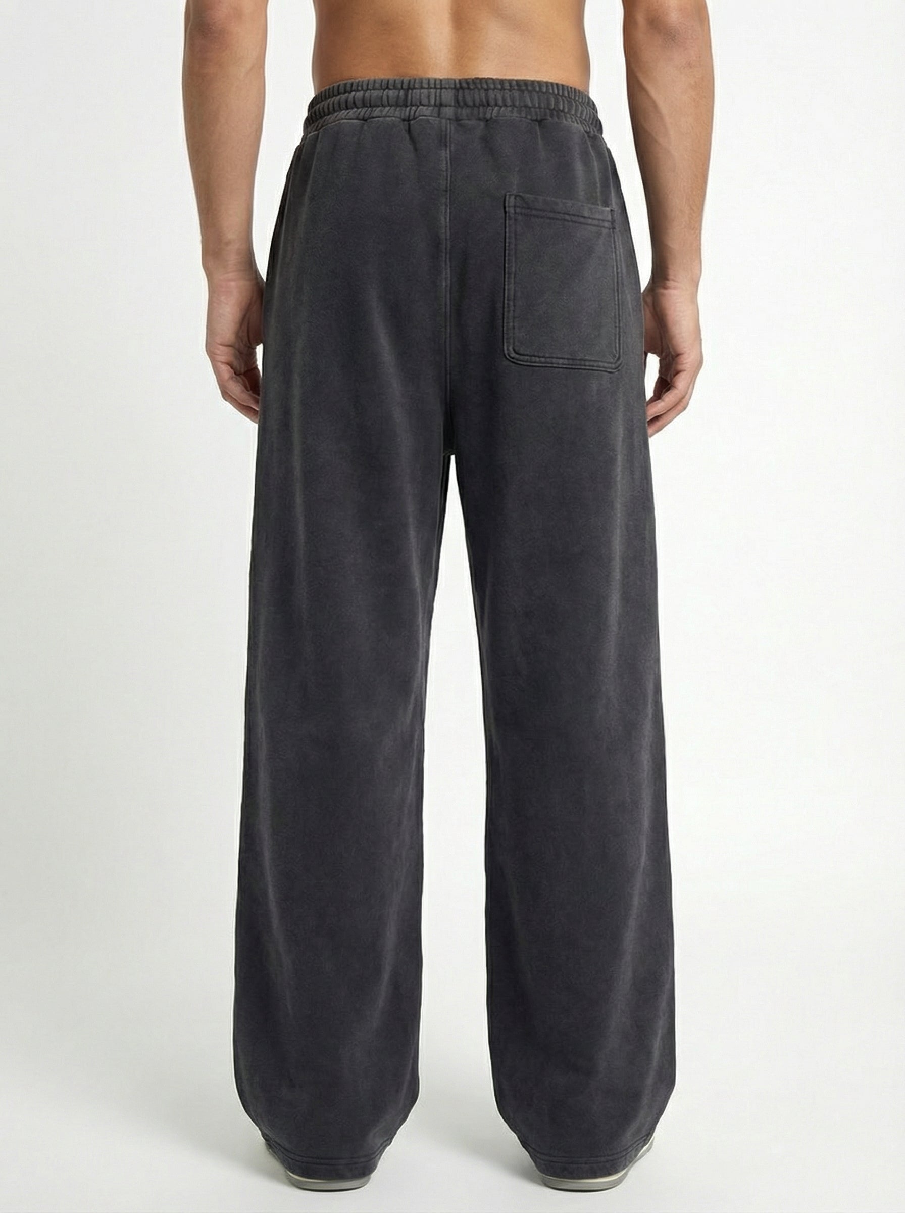 Dark gray sweatpants worn by a person on a white background