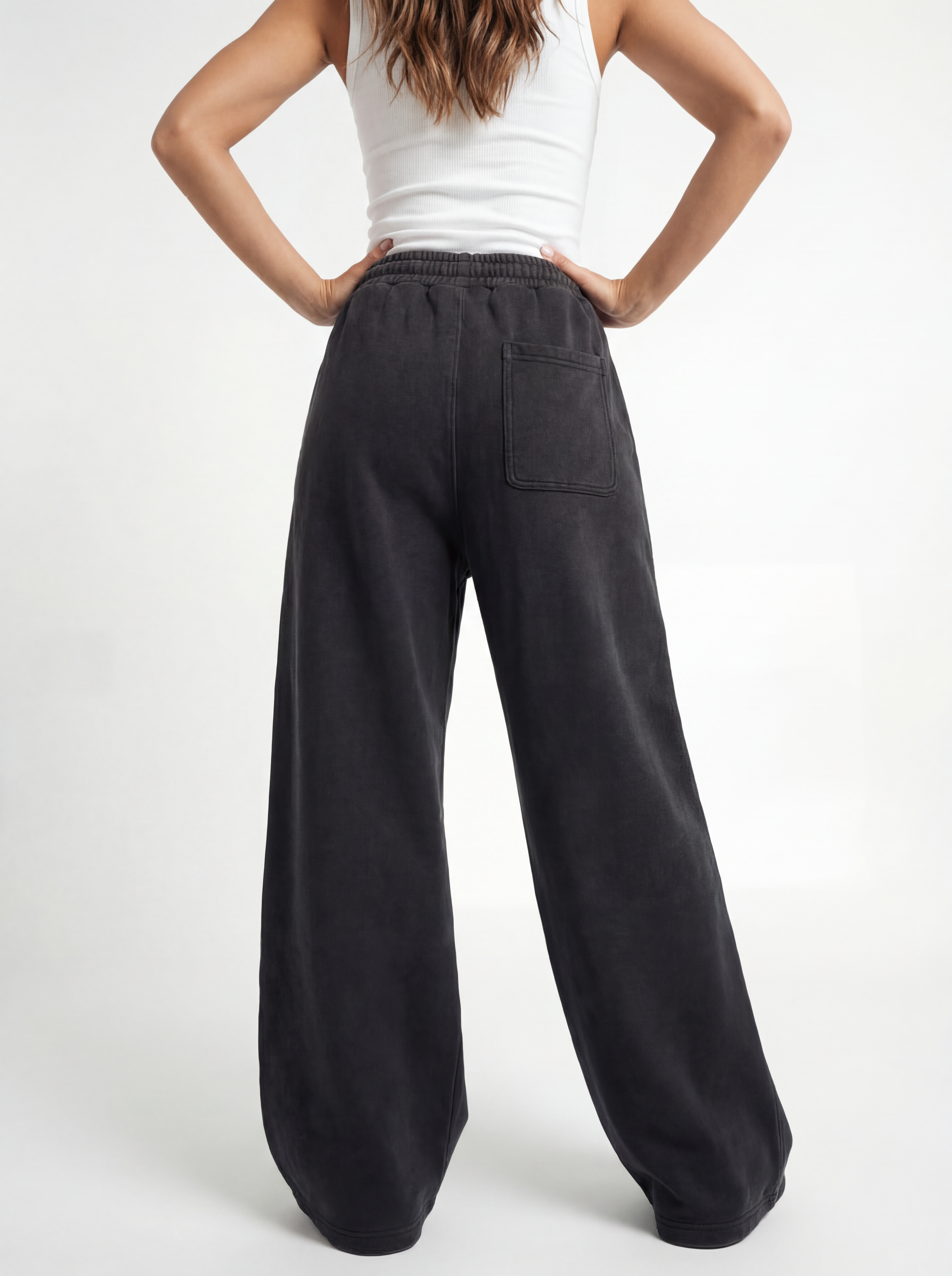 Person wearing black wide-leg pants and a white top on a white background