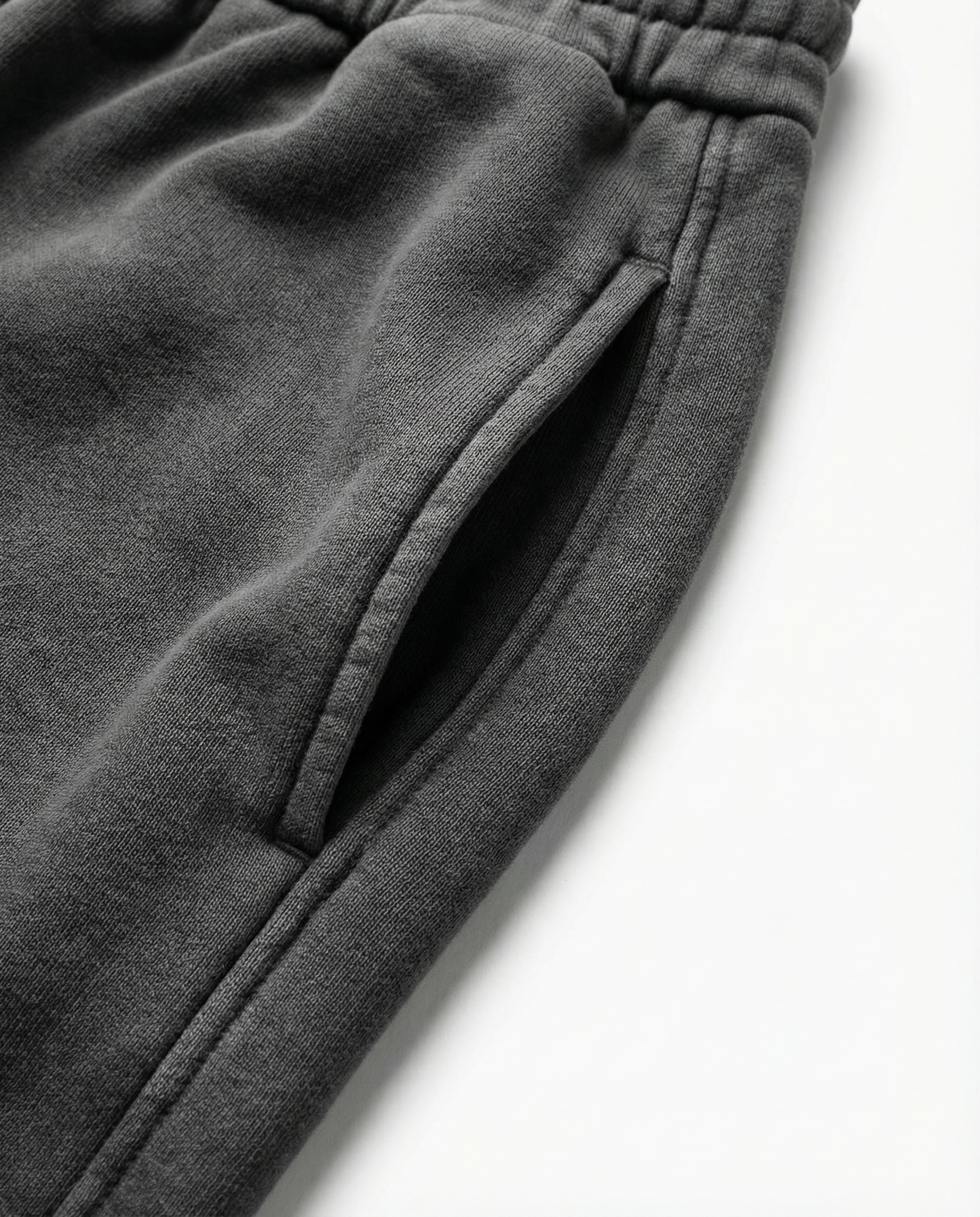 Close-up of dark gray sweatpants on a white background