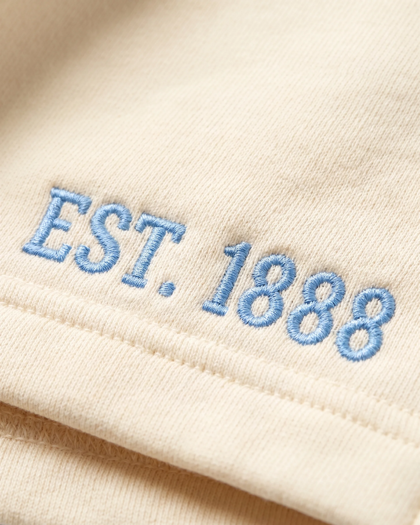 Tri Delta mockneck top detail — powder-blue EST. 1888 embroidery on butter-cream sorority sweatshirt