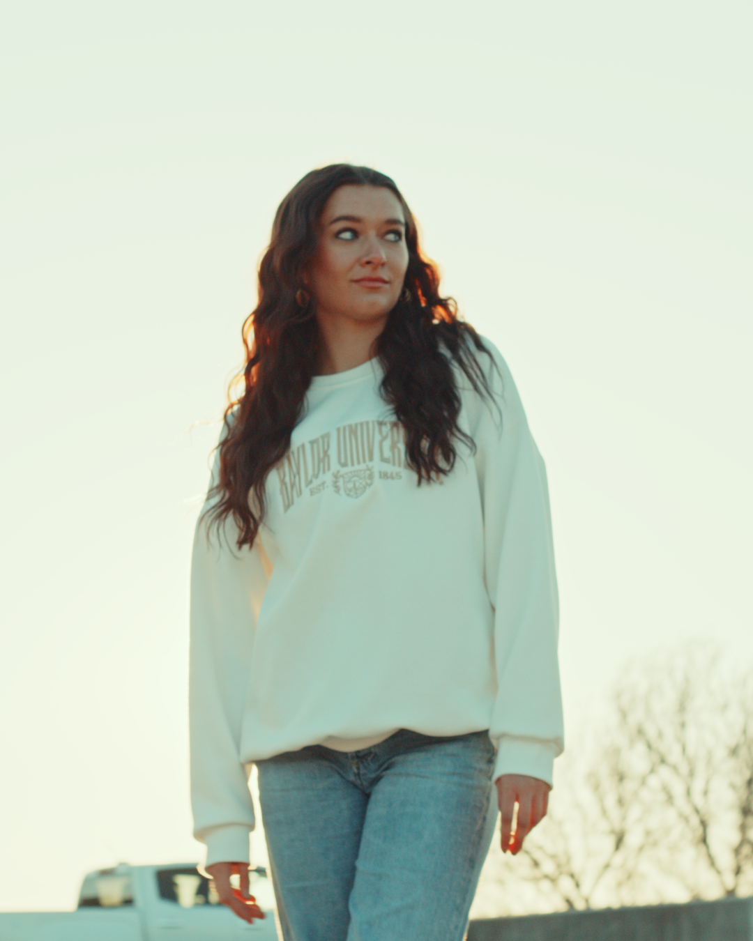 Woman wearing a white Baylor University sweatshirt outside