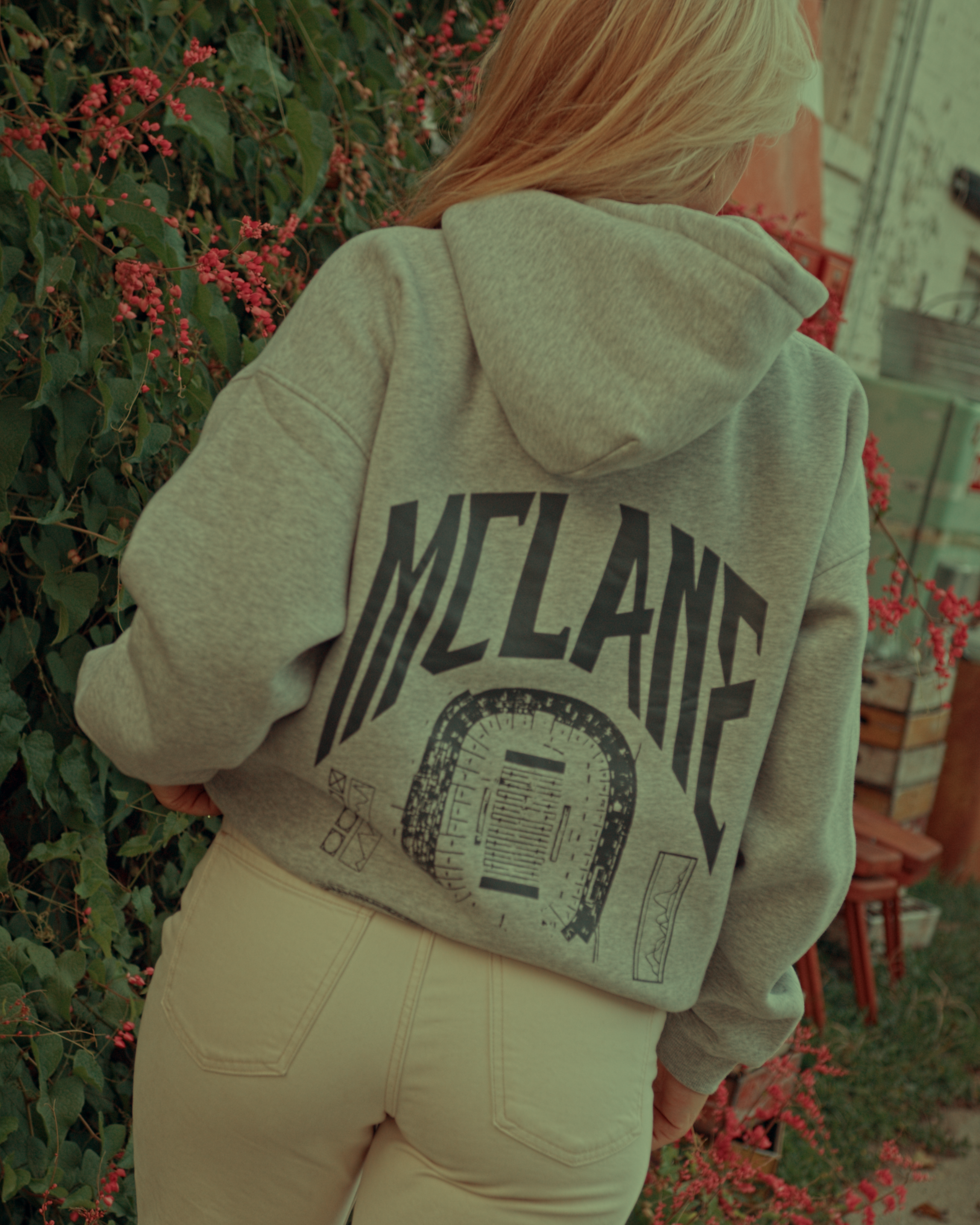 Person wearing a hoodie with 'McLane' branding outdoors.