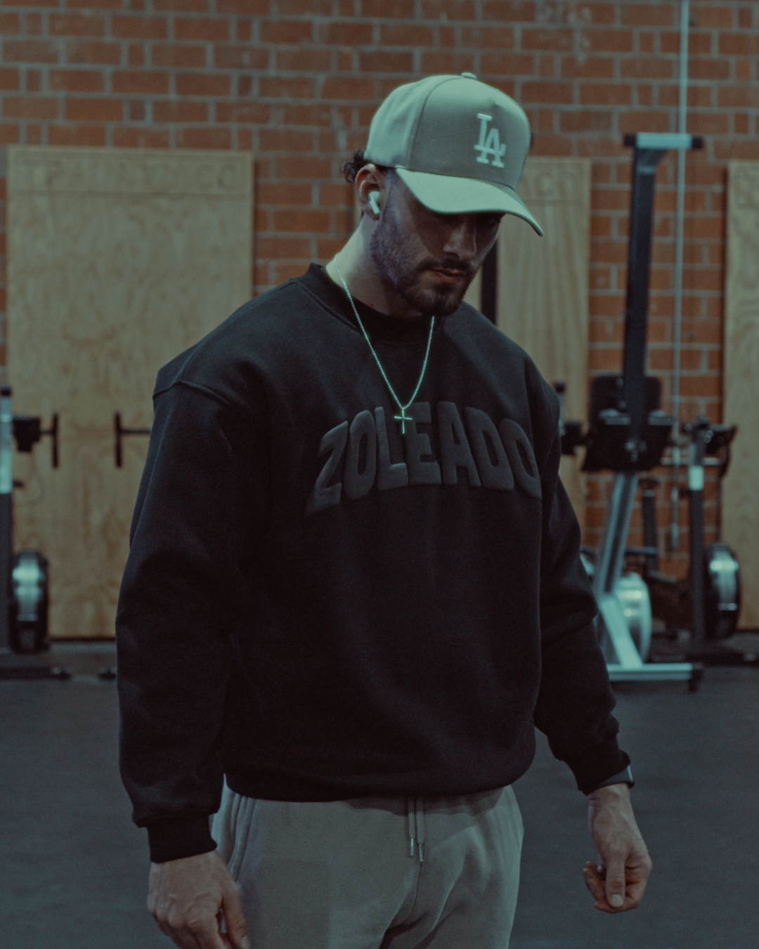 hot male model wearing an LA hat wearing a black zoleado puff print crewneck