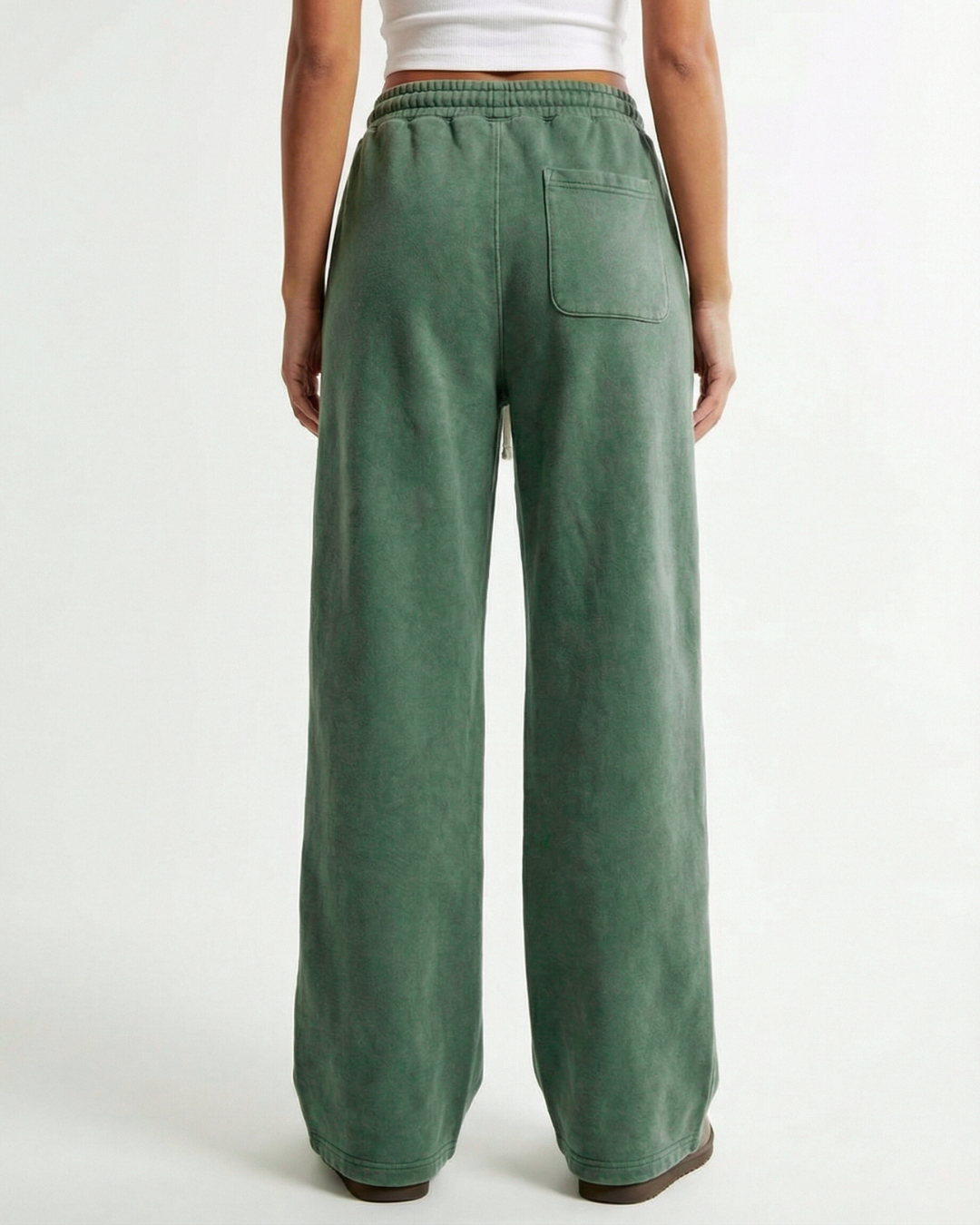 Green wide-leg washed green pants worn by a person on a white background