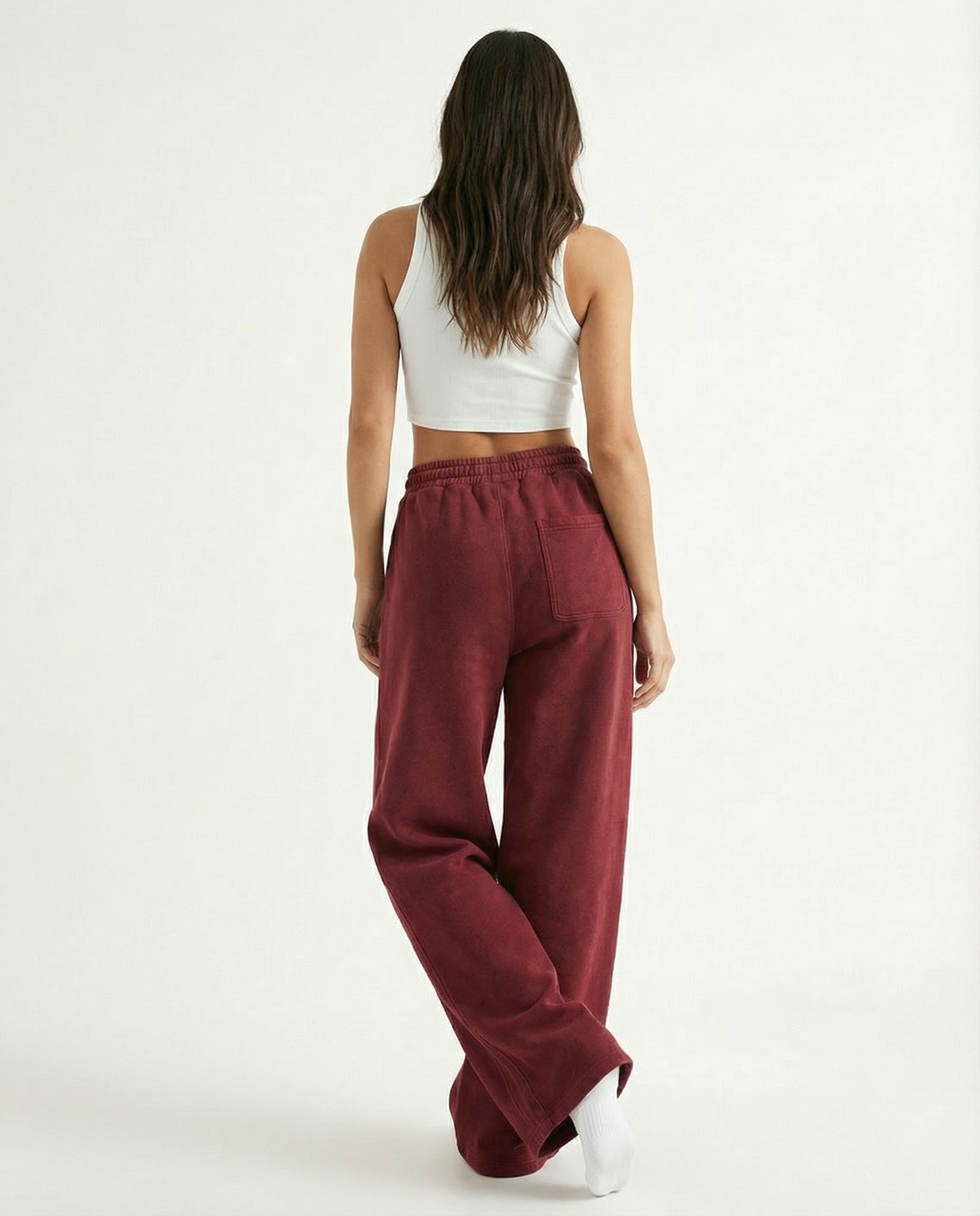 Person wearing red pants and a white top on a white background