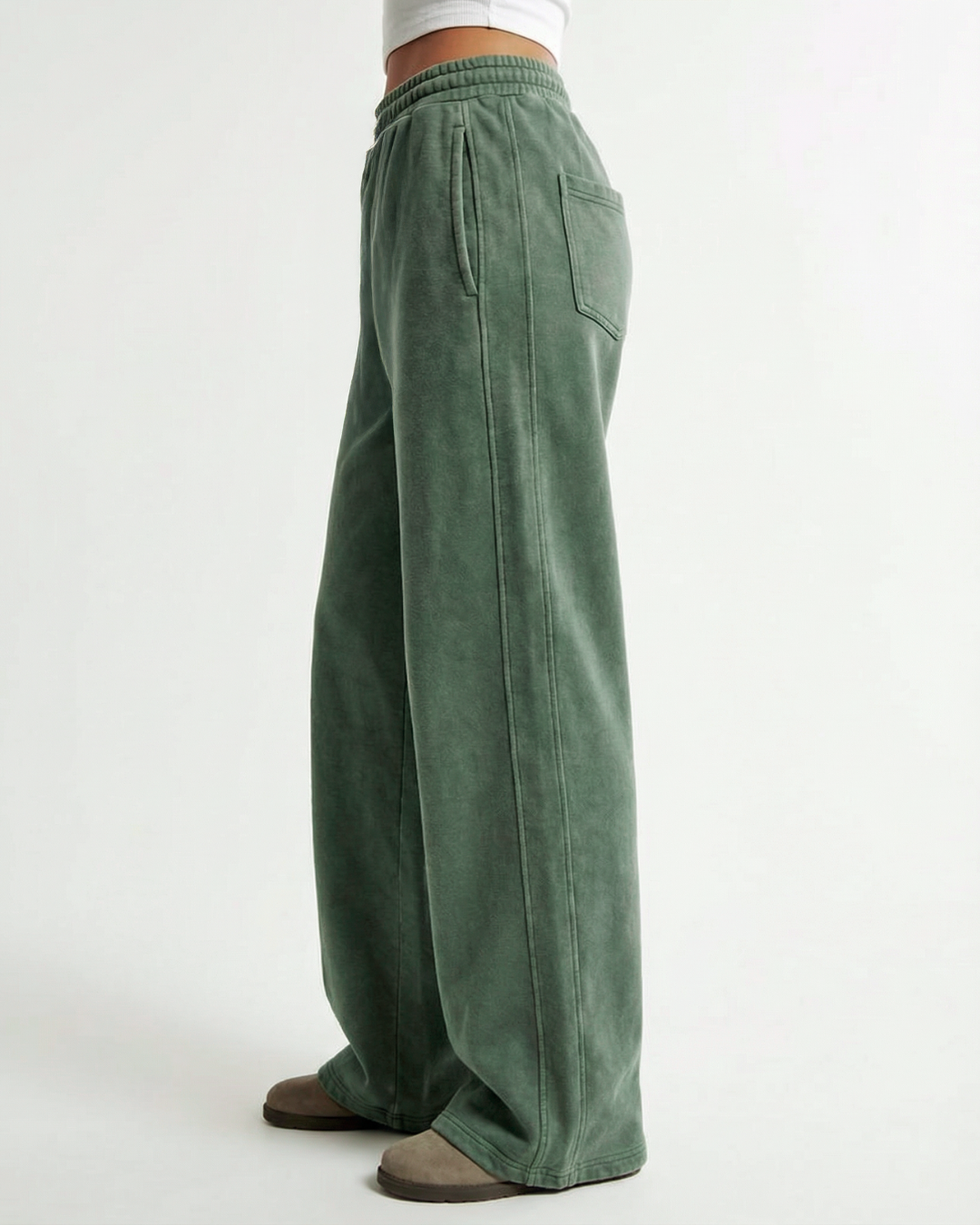 Green wide-leg acid wash pants worn by a person on a white background