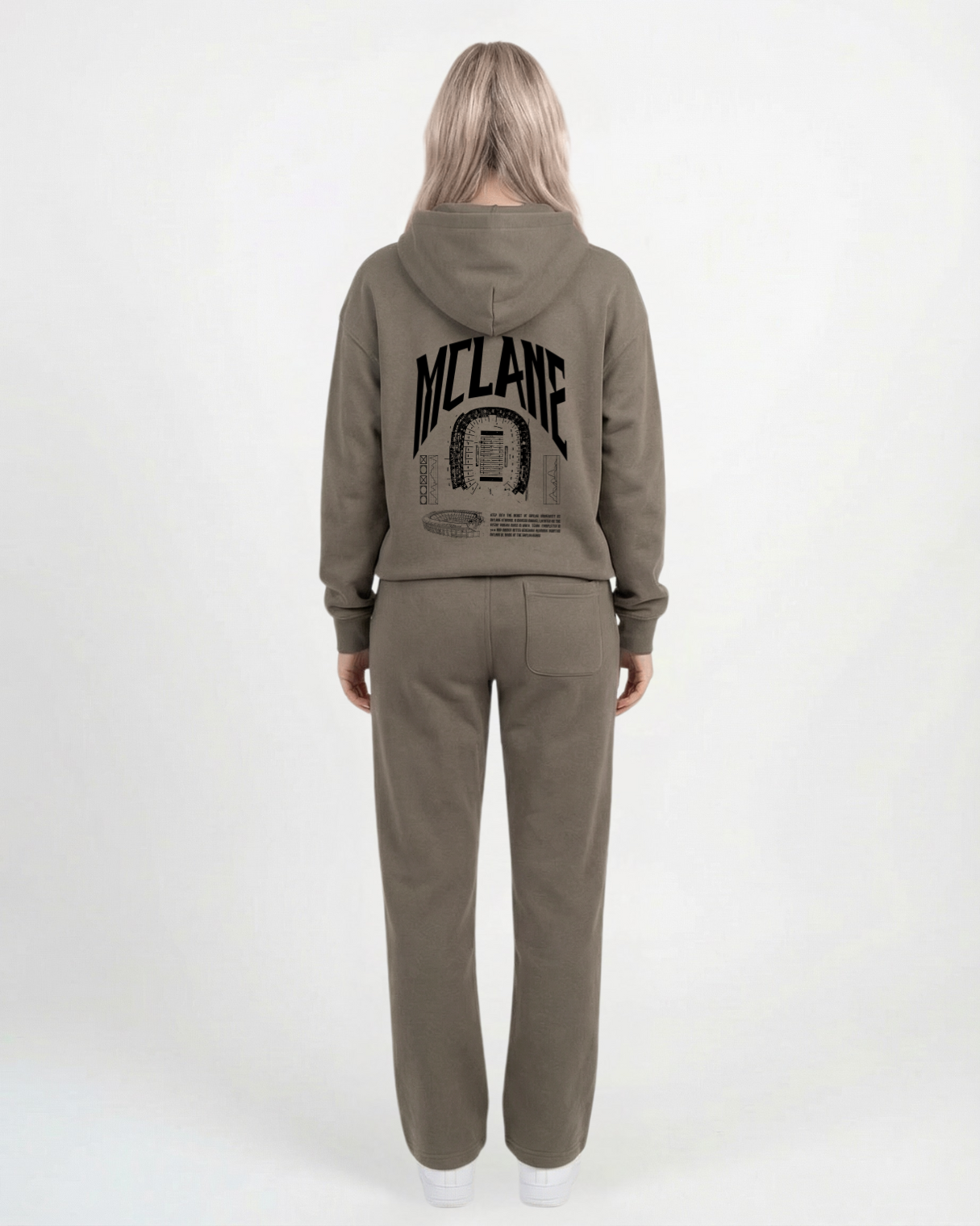 woman wearing an olive green tracksuit with 'McLane' branding on the back against a white background