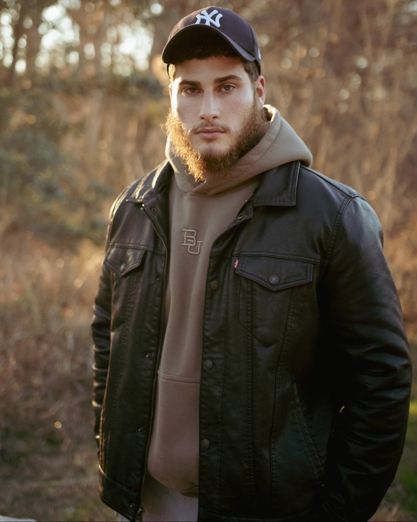 Male model wearing the baylor university mclane stadium hoodie with a leather jacket on top
