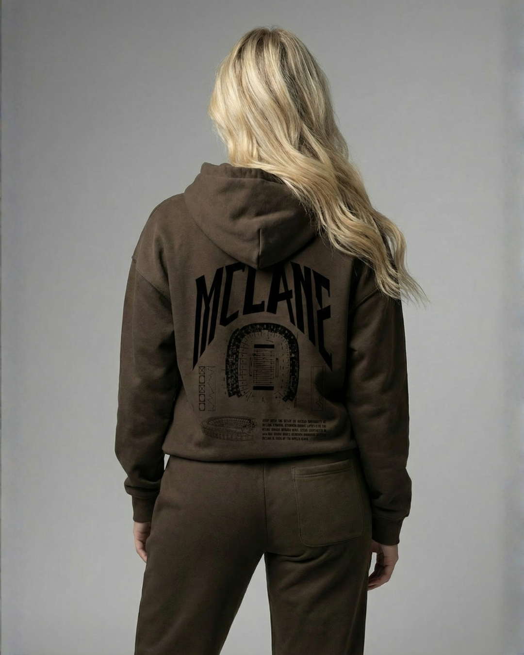 Person wearing a brown hoodie with 'McLane' branding on the back against a gray background
