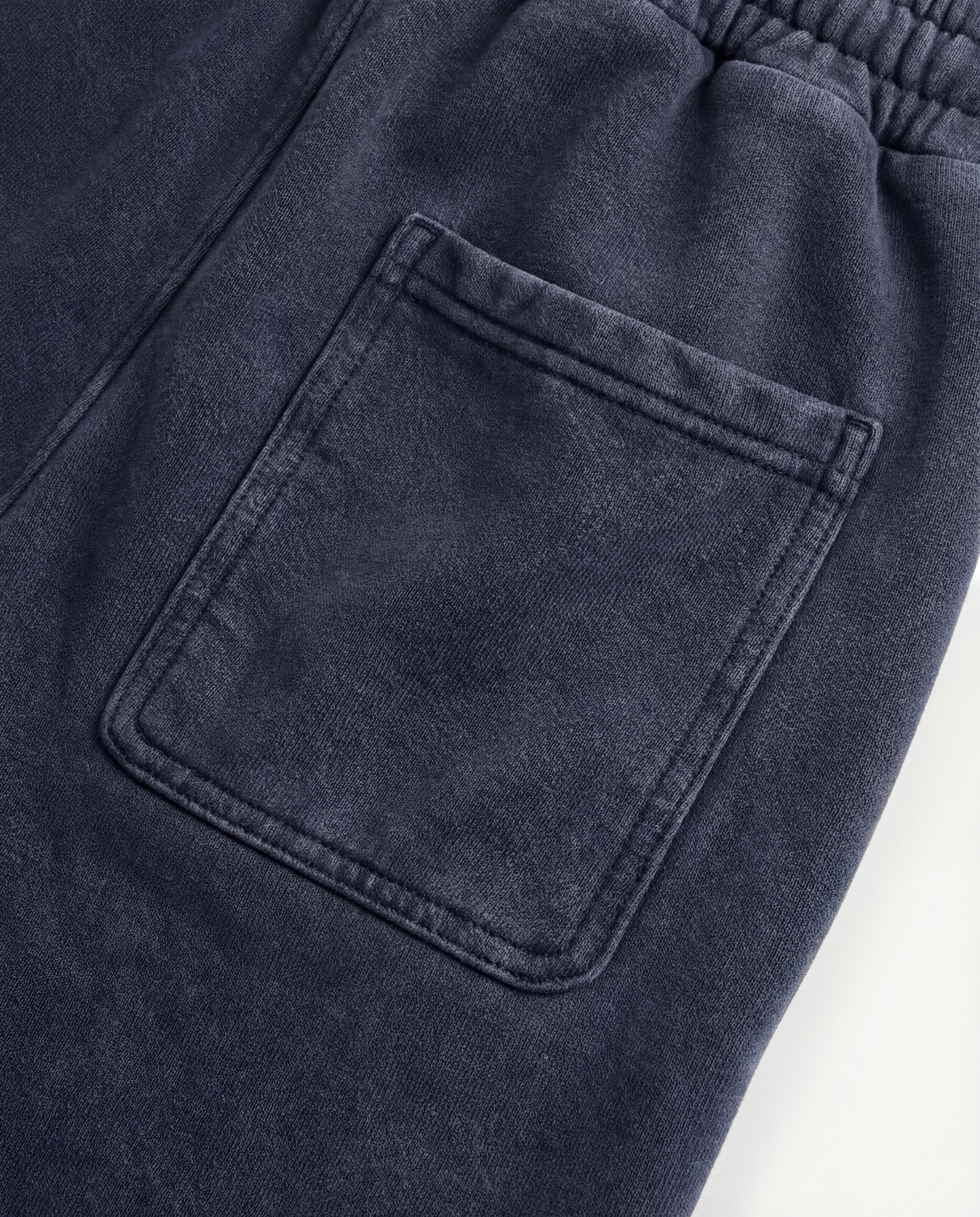 Close-up of blue acid wash sweatpants fabric and pocket detail