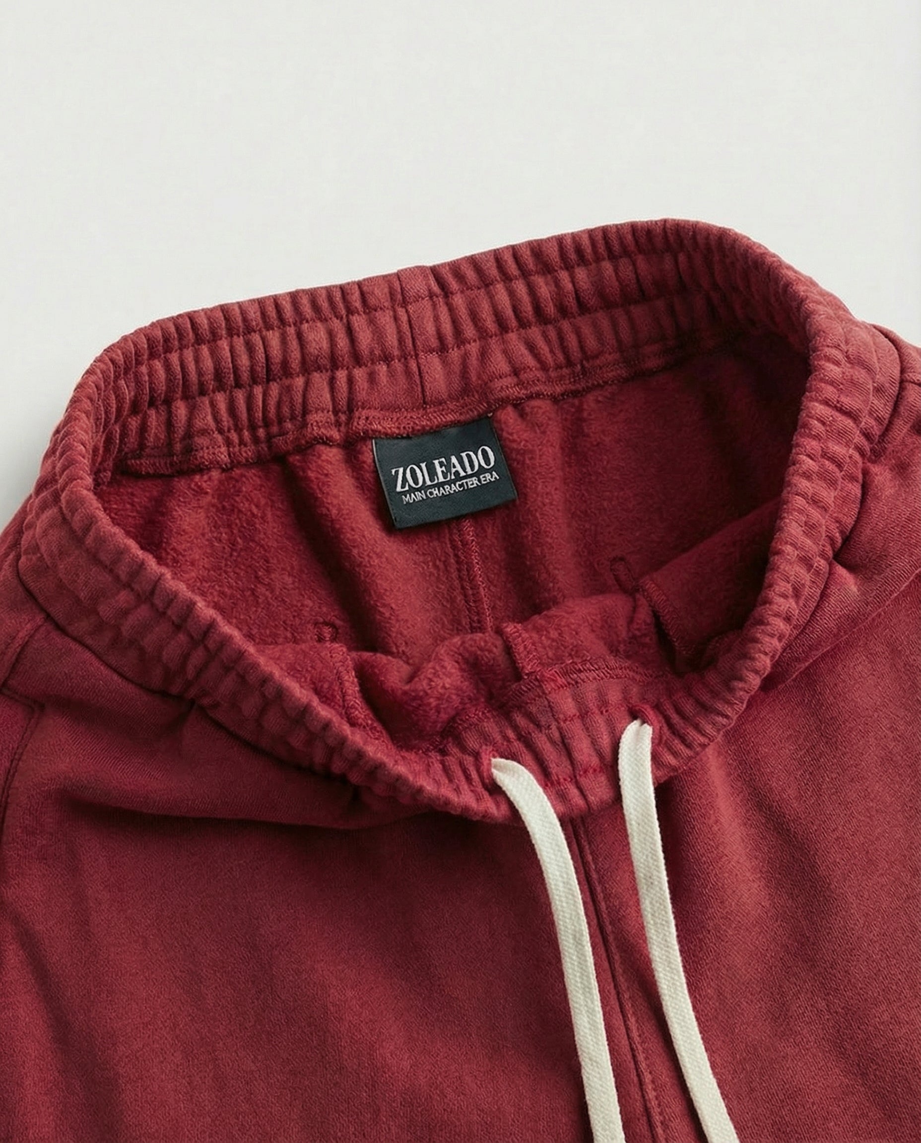 Close-up of crimson red acid wash sweatpants fabric and pocket detail