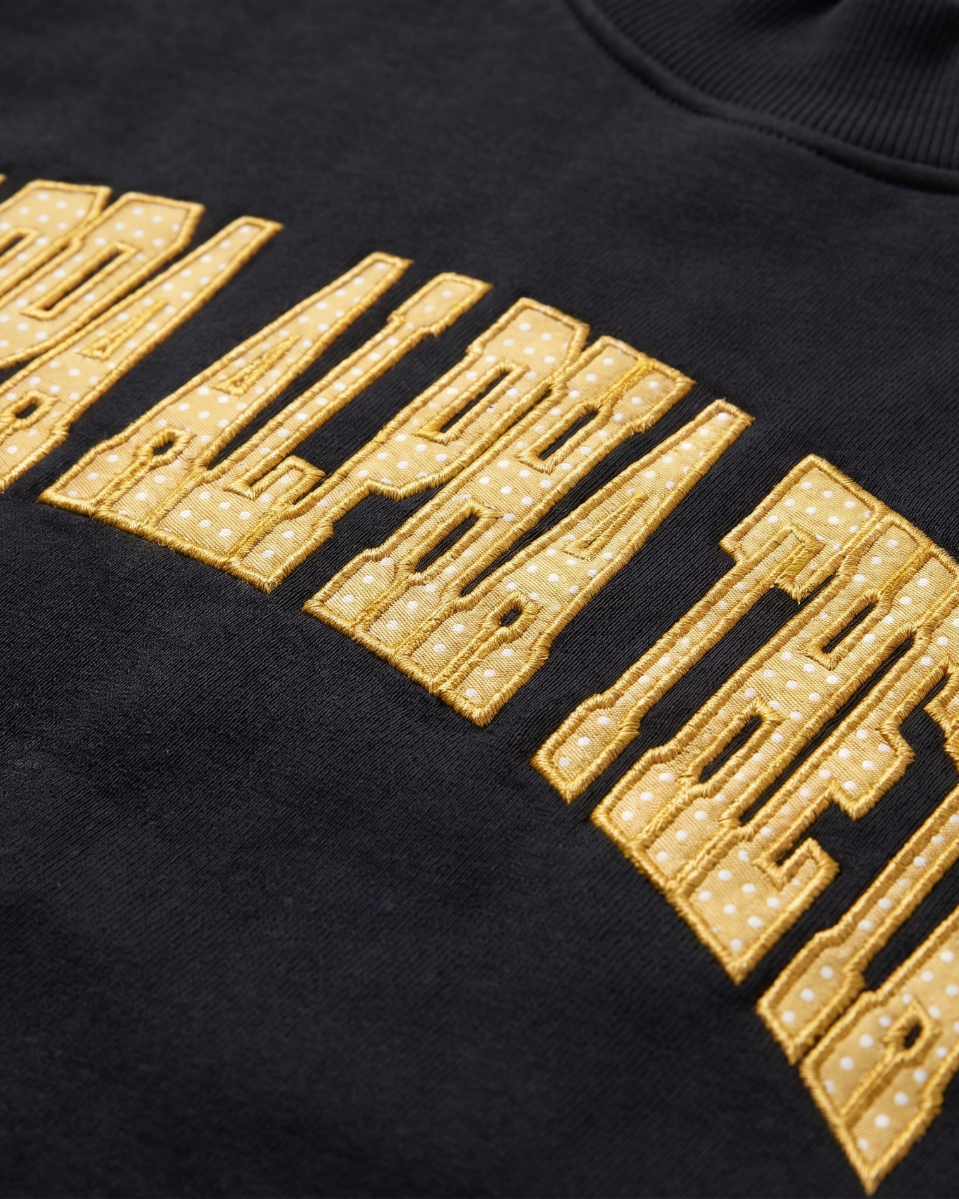 Kappa Alpha Theta chest patch embroidery close-up - gold polka-dot tackle-twill lettering on black