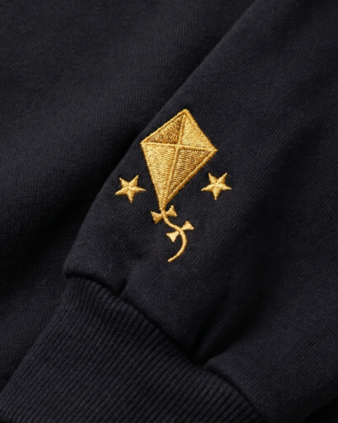 Kappa Alpha Theta sleeve charm close-up - embroidered gold kite and stars on black fleece