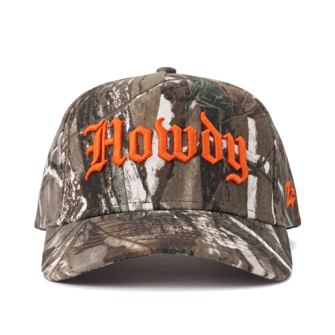 Howdy camo trucker hat front — woodland camo cap with raised orange blackletter Howdy embroidery