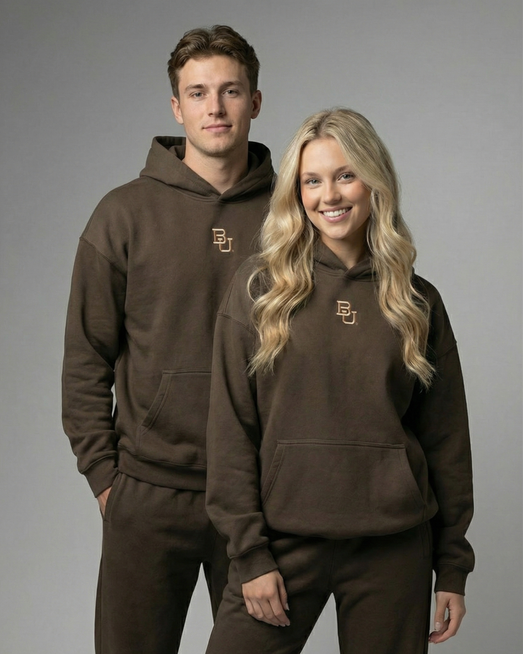 Guy and girl wearing brown baylor university mclane stadium hoodies 