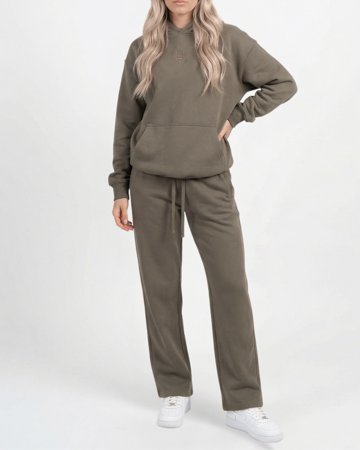 Person wearing an olive green tracksuit on a white background